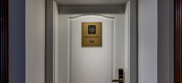 Privater Saunabereich mit Holzsauna, Relaxliege, Dusche und stimmungsvoller Beleuchtung – ideal für exklusive Wellnessmomente.
